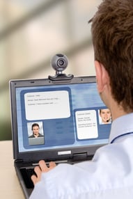online customer support - business man having an online chat with another person via webcam and headsets